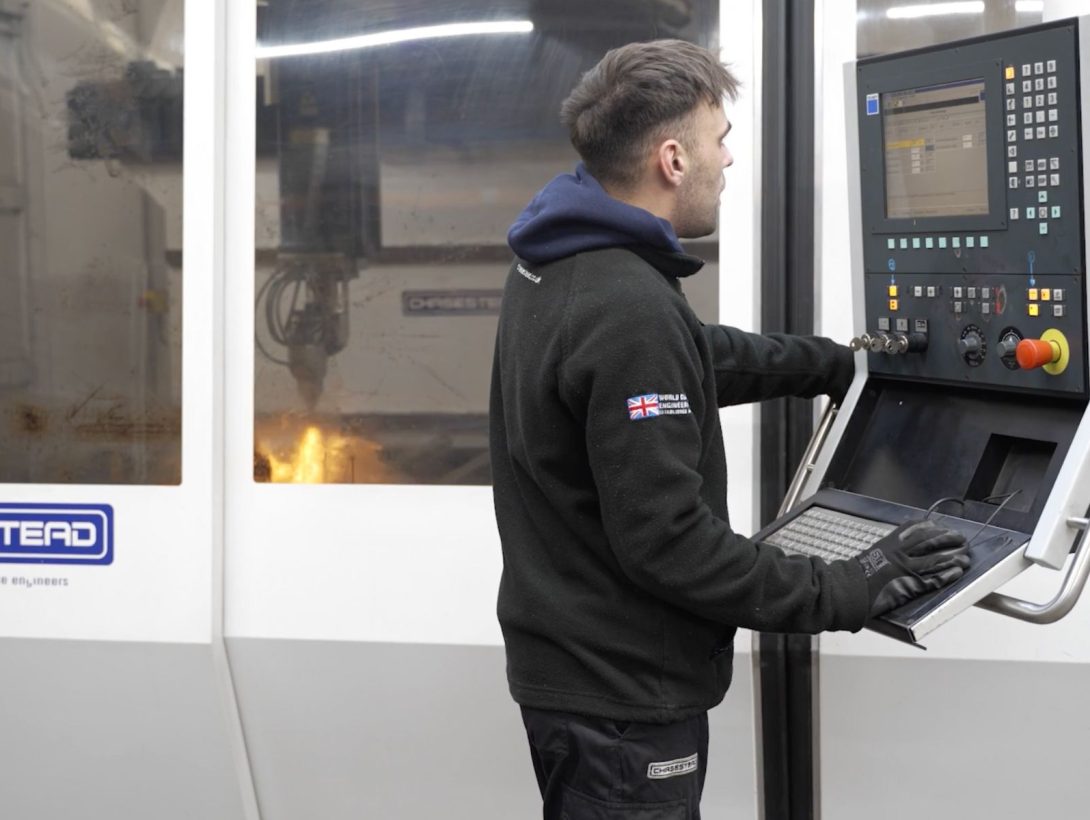 Laser cutting operator using CNC control panel for precision metal cutting